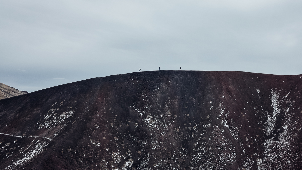 People circumnavigating the craters of Mount Etna