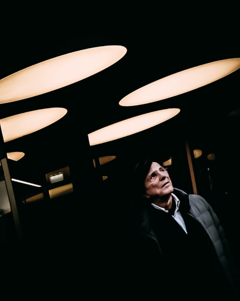 A man exiting a shopping center at night in Berlin