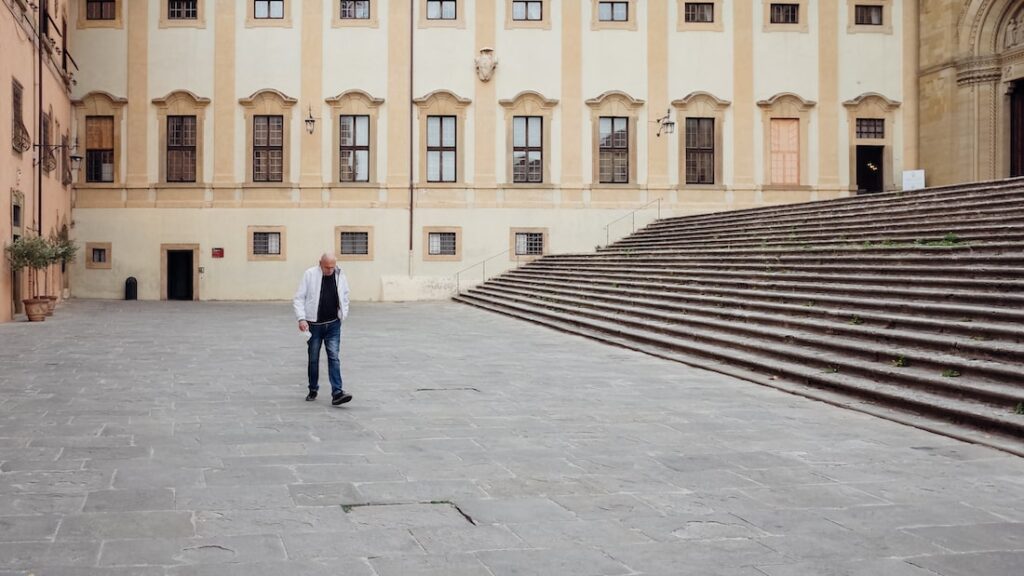 A man walking outside the Arezzo Cathedral