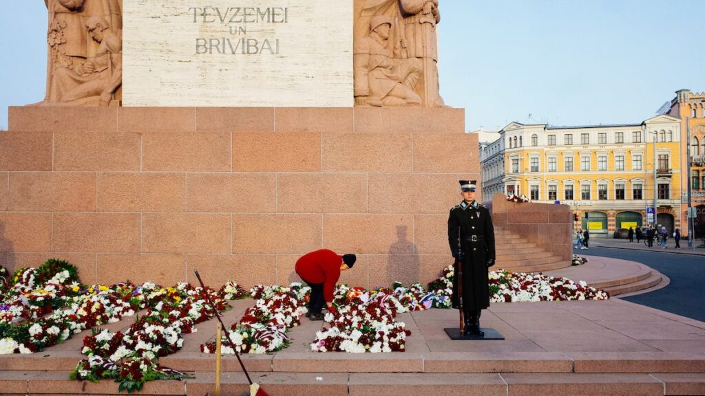 A woman arranging flowers in Freedom Monument during the Latvia Independence celebration in Riga, Latvia