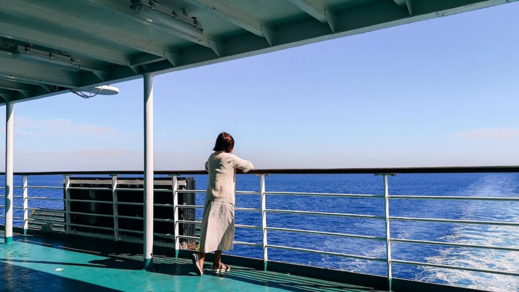 A woman enjoying the view from the deck of a ferry