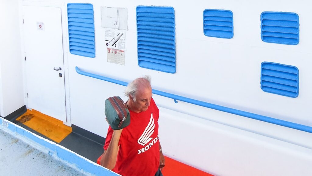 A man is walking on the deck of a Greek ferry.