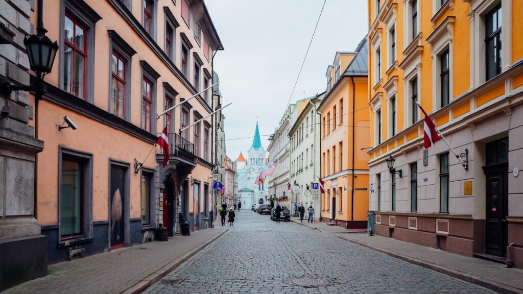 A photo showing a street leading to a church and the Swedish Gate in Riga, Latvia