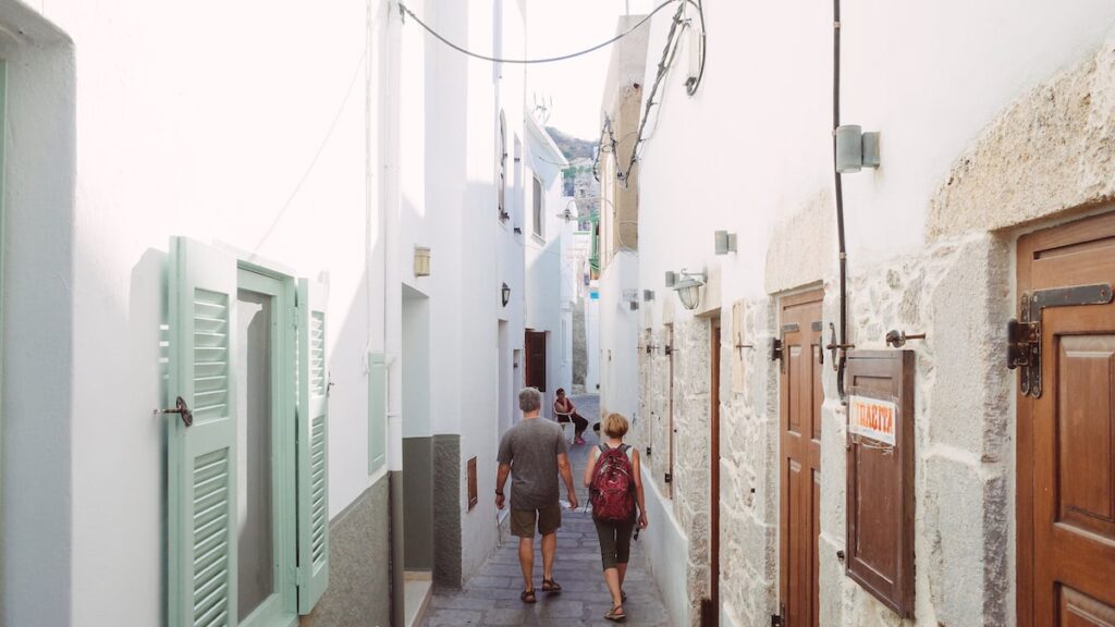 Two people walking the whitewashed streets of Mandraki. (Nisyros travel guide)