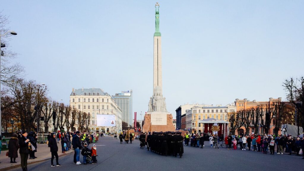 One of the top-rated things to do in Riga is to visit the iconic Freedom Monument. In the photo, you can also see a military parade heading toward the monument for Latvia's Independence Day.