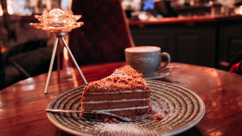 A photo showing the Traditional Latvian Honey Cake and a cup of coffee in a cafe in Riga Old Town called "The most romantic cafe"