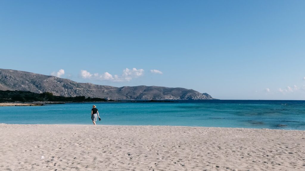 A photo of Elafonissi beach in Crete and a woman walking close to the water