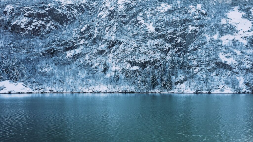 Semi-frozen sea and a slope covered in snow on a fjord cruise from Bergen to Mostaraumen