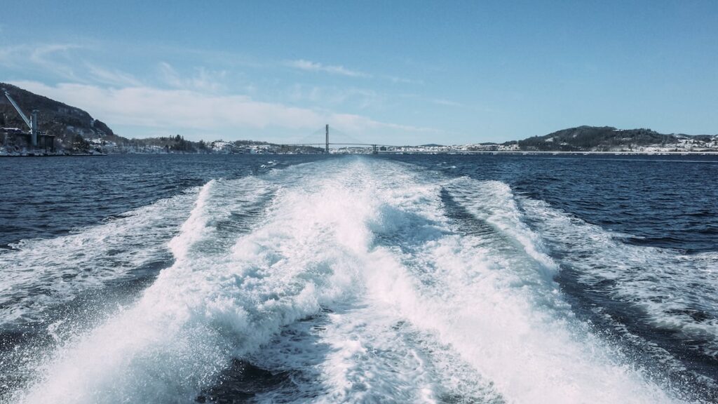A photo of waves just outside of Bergen, Norway, and in the background, the Nordhordland Bridge