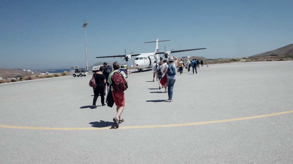 A bunch of people walking towards a small Sky Express plane serving a domestic route in Greece.