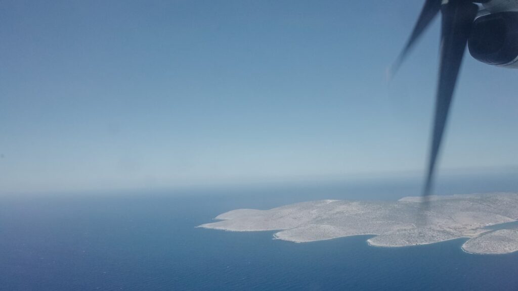 An aerial image of a Greek island. The photo is taken from a domestic flight in Greece