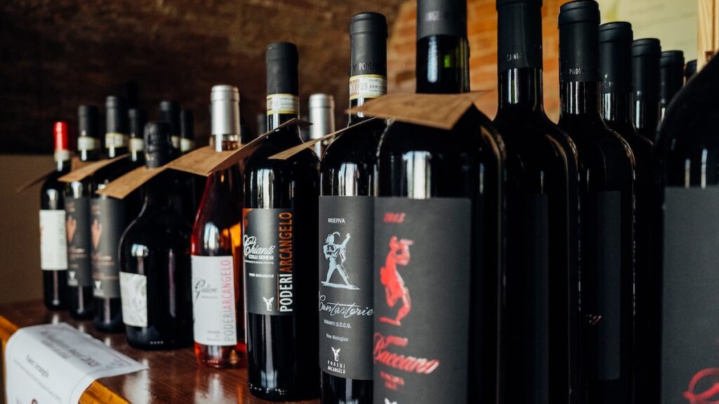 Several wine bottles from the Chianti region were placed on a shelf. It's part of a Tuscany wine tour from Florence