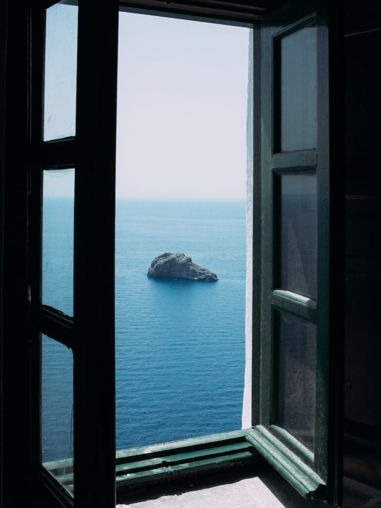 View from the window of the main room of Hozoviotissa Monastery in Amorgos. A small uninhabited island and the blue sea.