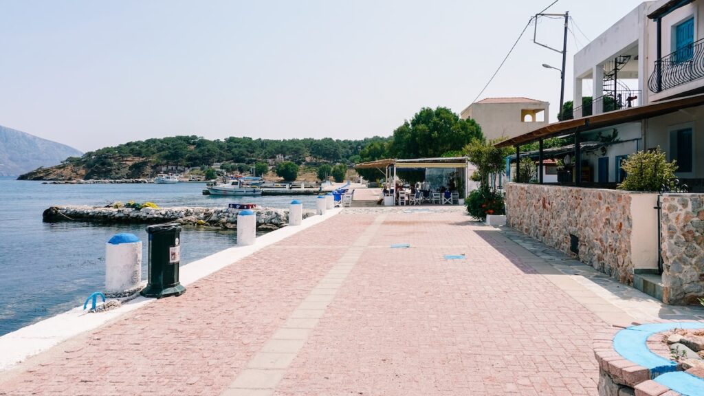 A photo showing the beachfront promenade of the tiny island of Telendos, in the Dodecanese, Greece
