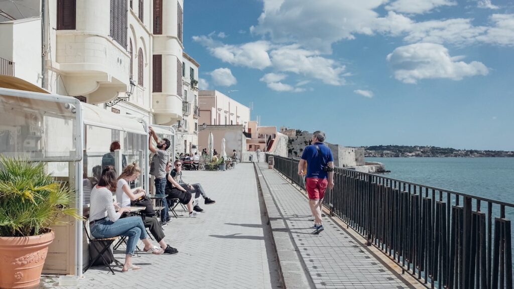 A photo showing people hanging out in a cafe in Syracuse, Italy