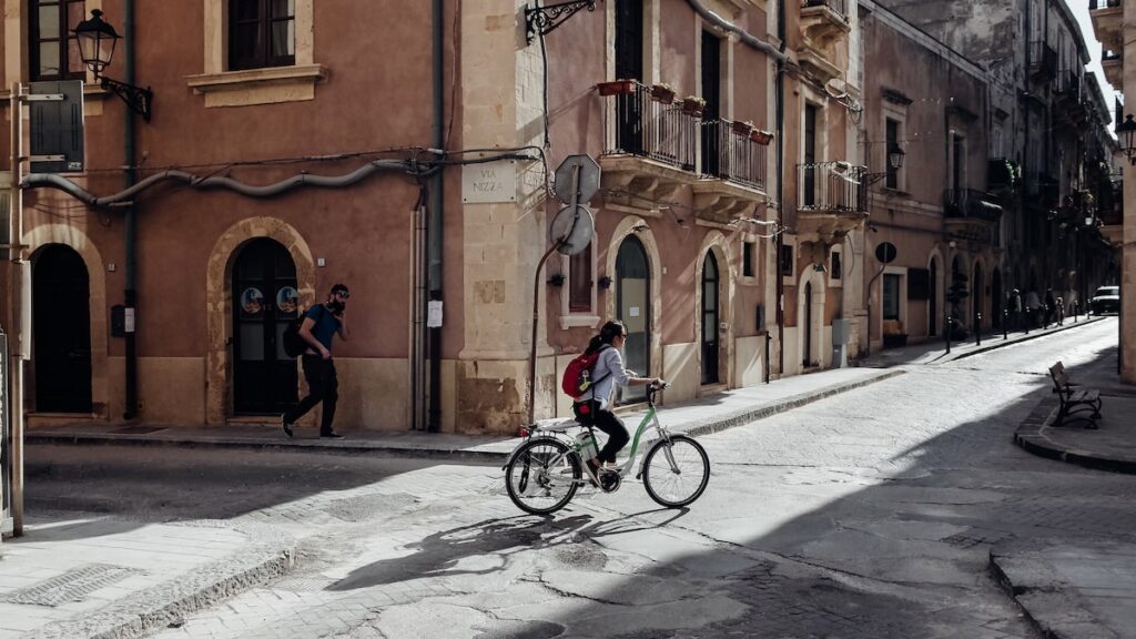 A woman cycling in Ortygia, Syracuse.