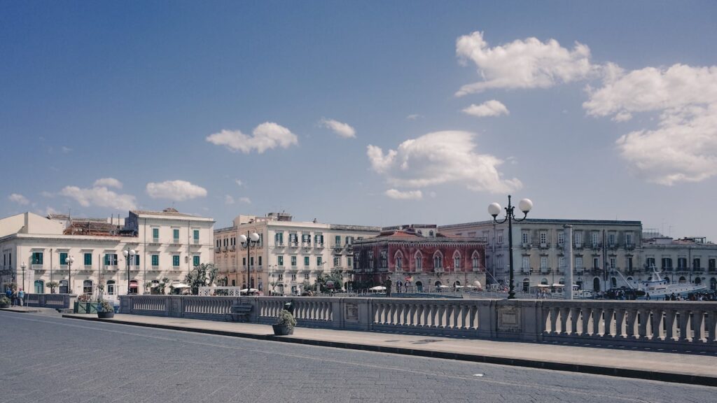 An image of a bridge leading to Ortygia, the most beautiful town in Italy and the place where the best Syracuse tours start from.