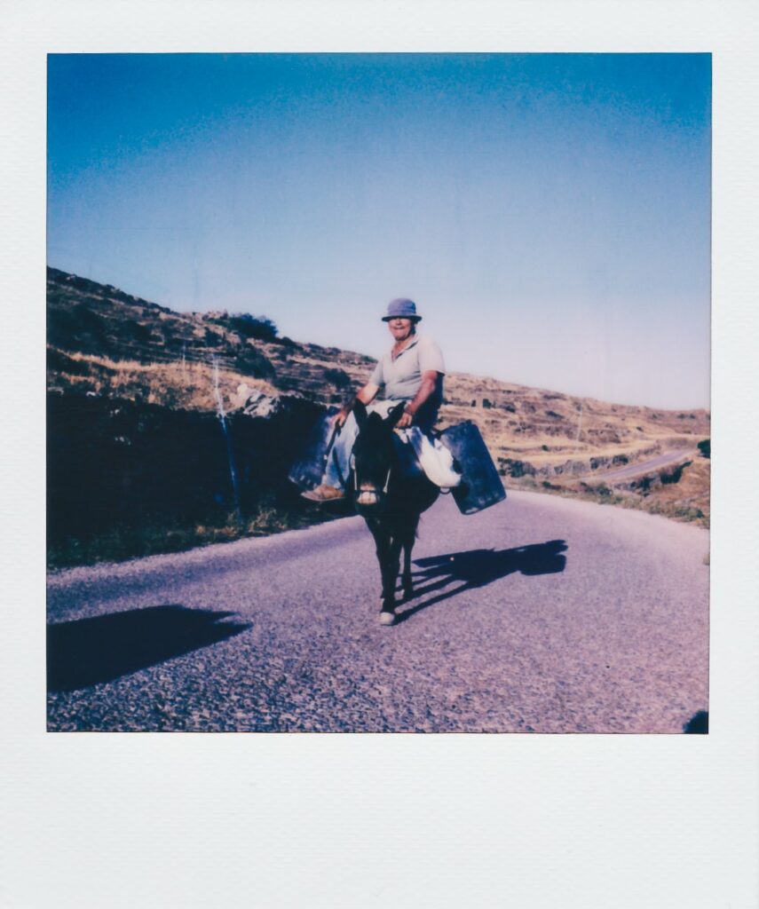 A polaroid of a man on a donkey in Folegandros, Greece, taken with the Polaroid SX-70