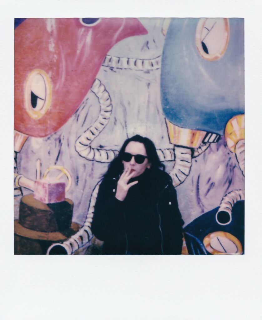A polaroid of Marianna in front of the Berlin Wall, taken with the Polaroid OneStep+