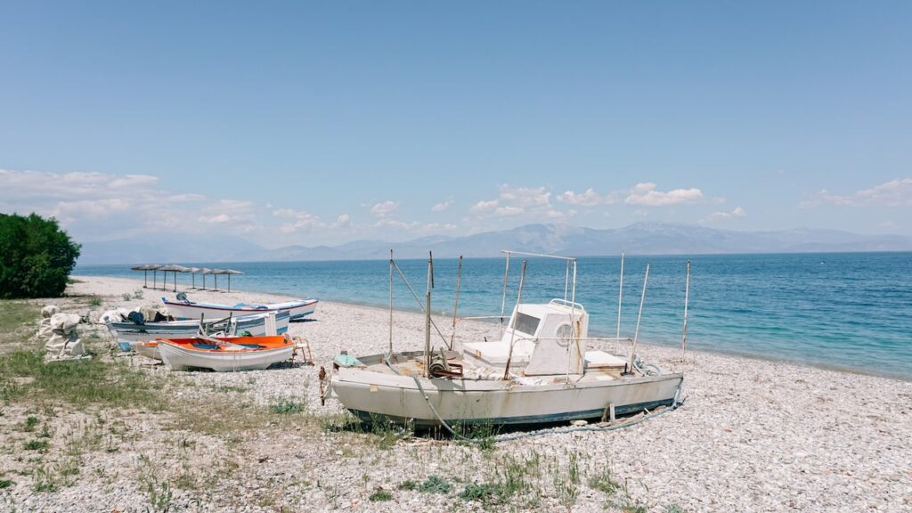An image of fishing boats laying on the beach of Sykia in the Peloponnese, Greece. The image serves as the cover photo of a Sykia travel guide written by George Pavlopoulos for the travel blog Letters to Barbara.