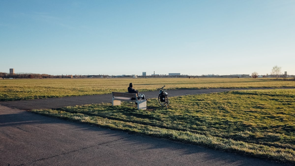 A photo of a man unwinding next to his bike at the former Tempelhof Airport in Berlin, Germany.