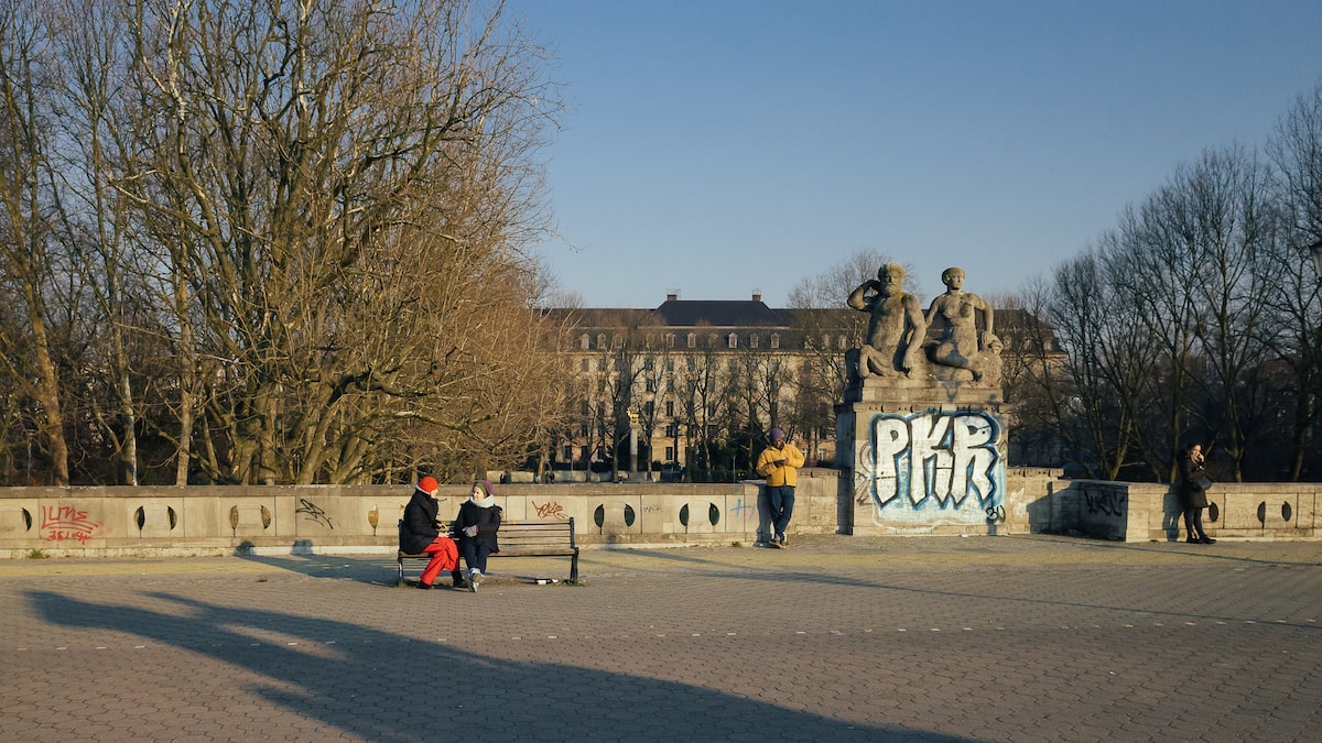 A photo taken from a bike tour in Berlin, showing a bridge in Schoneberg and people enjoying the late afternoon winter sun.
