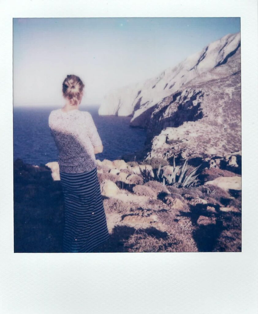 A polaroid of Barbara overlooking the Monolith in Anafi, taken with the Polaroid Impulse AF.