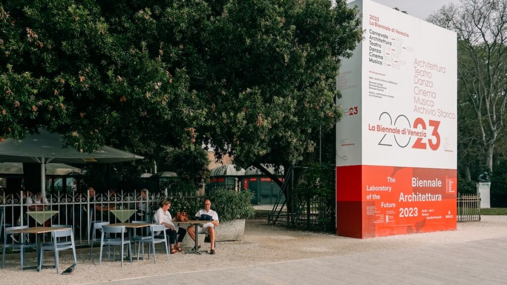 A photo of a cafe and next to it a poster during the Venice Biennale