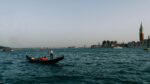 A photo showing a gondola in the Venetian Lagoon and the San Giorgio Maggiore island behind it. The image serves as the cover photo for an article about how to take a gondola ride in Venice written by George Pavlopoulos for the travel blog Letters to Barbara
