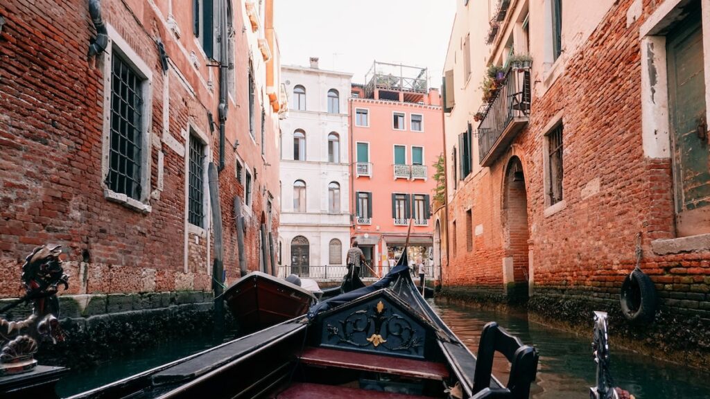 A photo showing a gondola crossing the inner canals of Venice