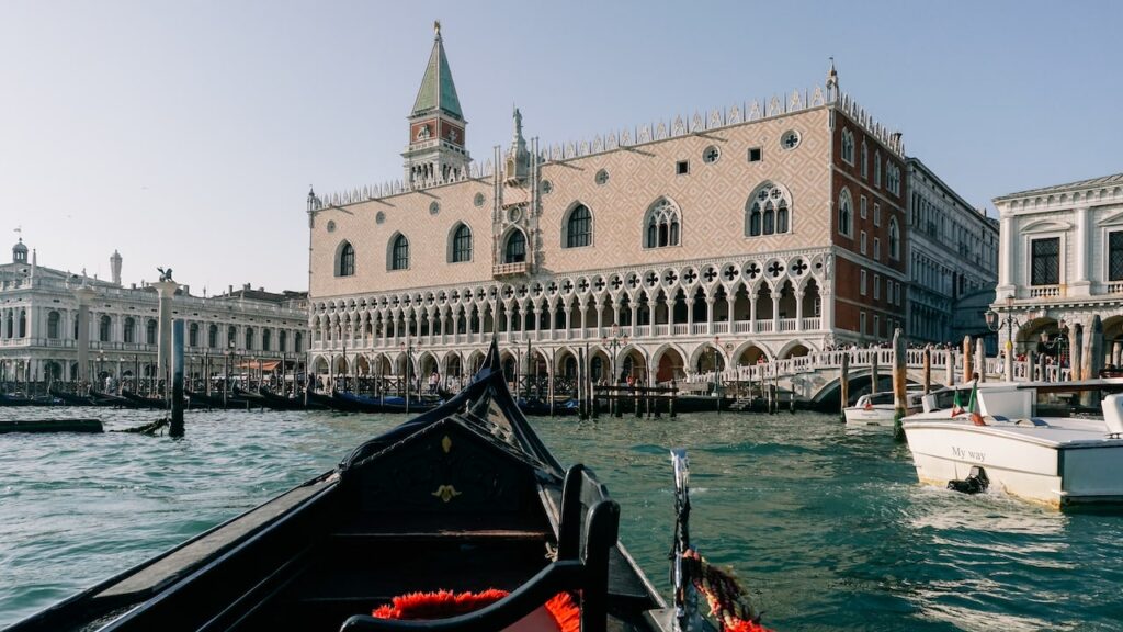 A photo showing a gondola ride in Venice, overlooking the Doge's Palace