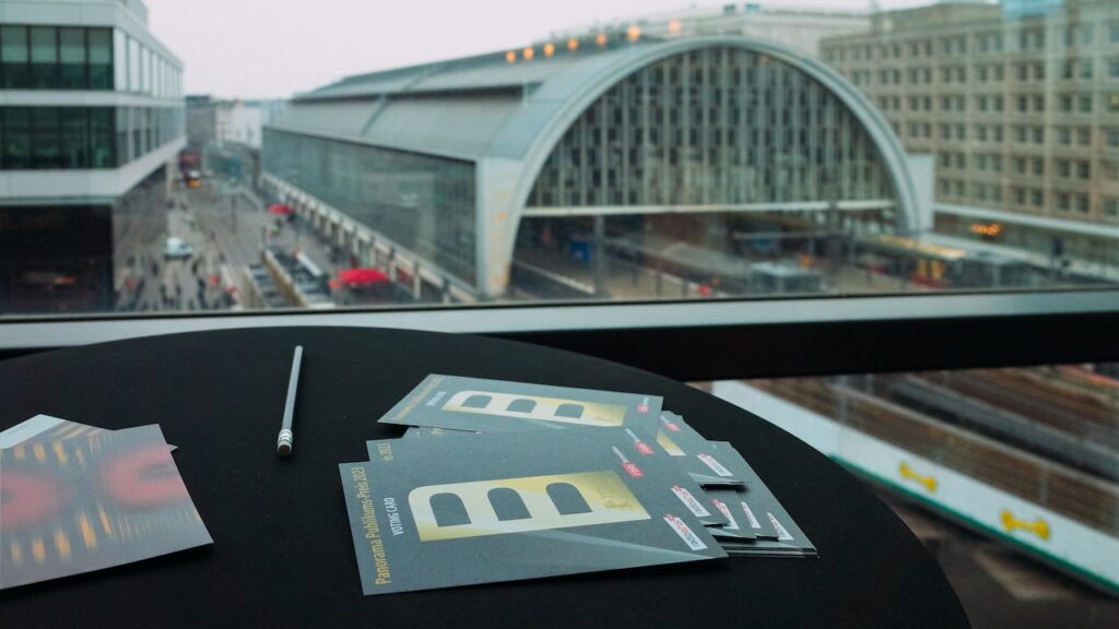 A photo of the voting cards for the Berlinale Panorama Audience Award and the station of Alexanderplatz in the background