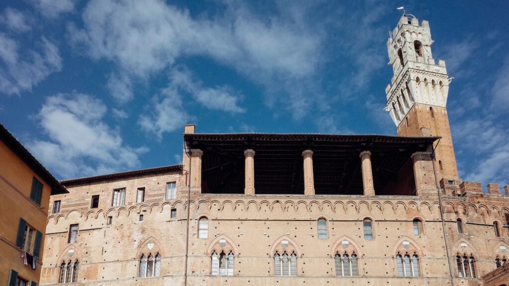 A photo showing the Torre del Mangia from a backstreet next to Piazza del Campo