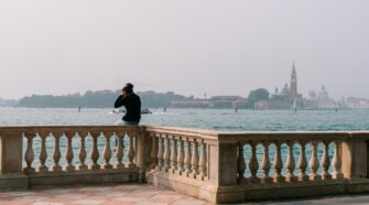 A woman enjoying the lagoon views in Venice, Italy. The image serves as the cover photo for an article about the best walking tours in Venice written by George Pavlopoulos for the travel blog Letters to Barbara