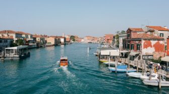 A photo of a water taxi crossing the Grand Canal of Murano. The image serves as the cover photo of an article about the best things to do in Murano written by George Pavlopoulos for the travel blog Letters to Barbara