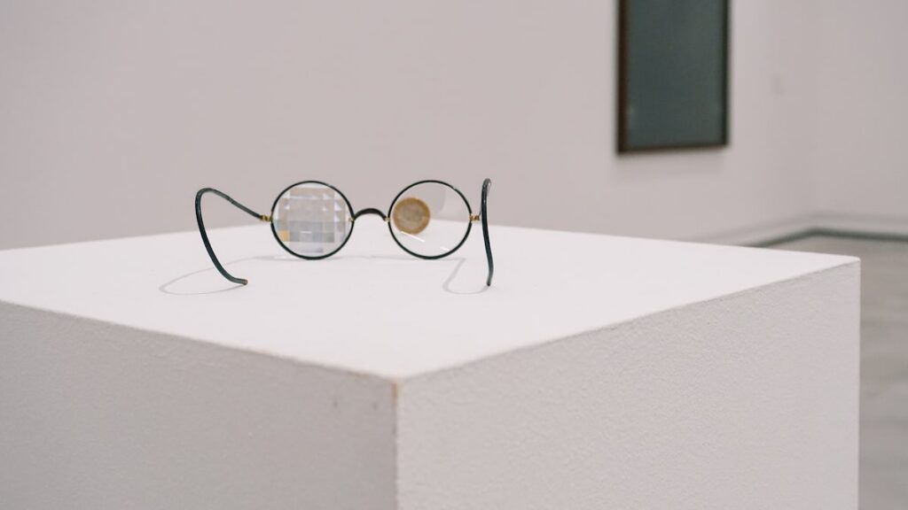 Detail of an artwork featuring a pair of glasses and a coin at Cukrarna Gallery