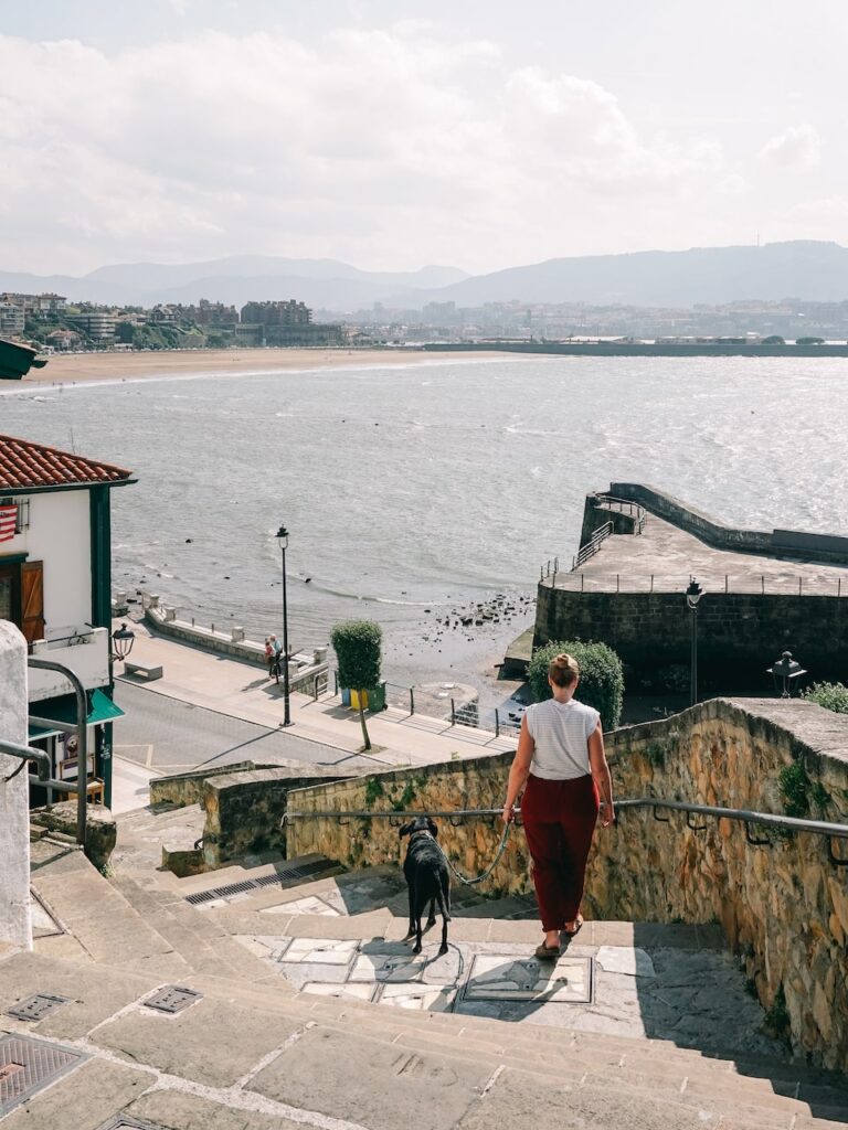 A woman walking her dog at Algorta, the old port of Getxo