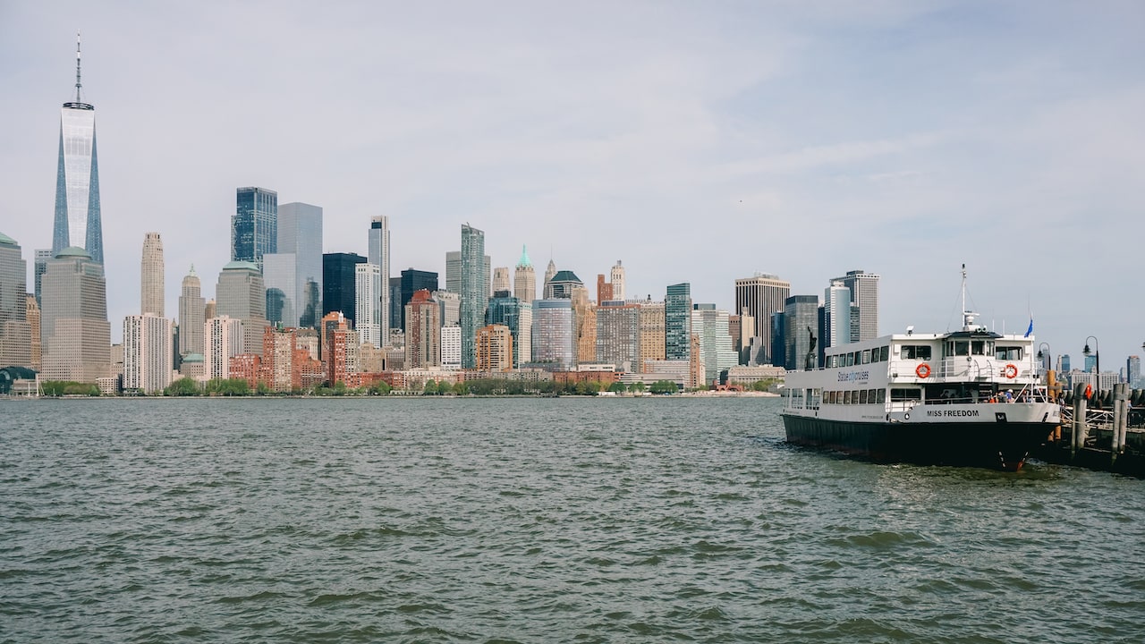 The ferry to Ellis Island and the Statue of Liberty and the skyline of Manhattan in the background