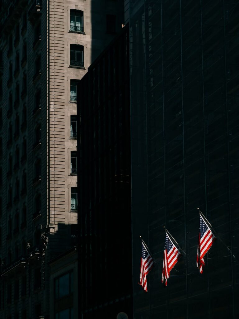 Three American flags and the tall buildings of Manhattan in New York City