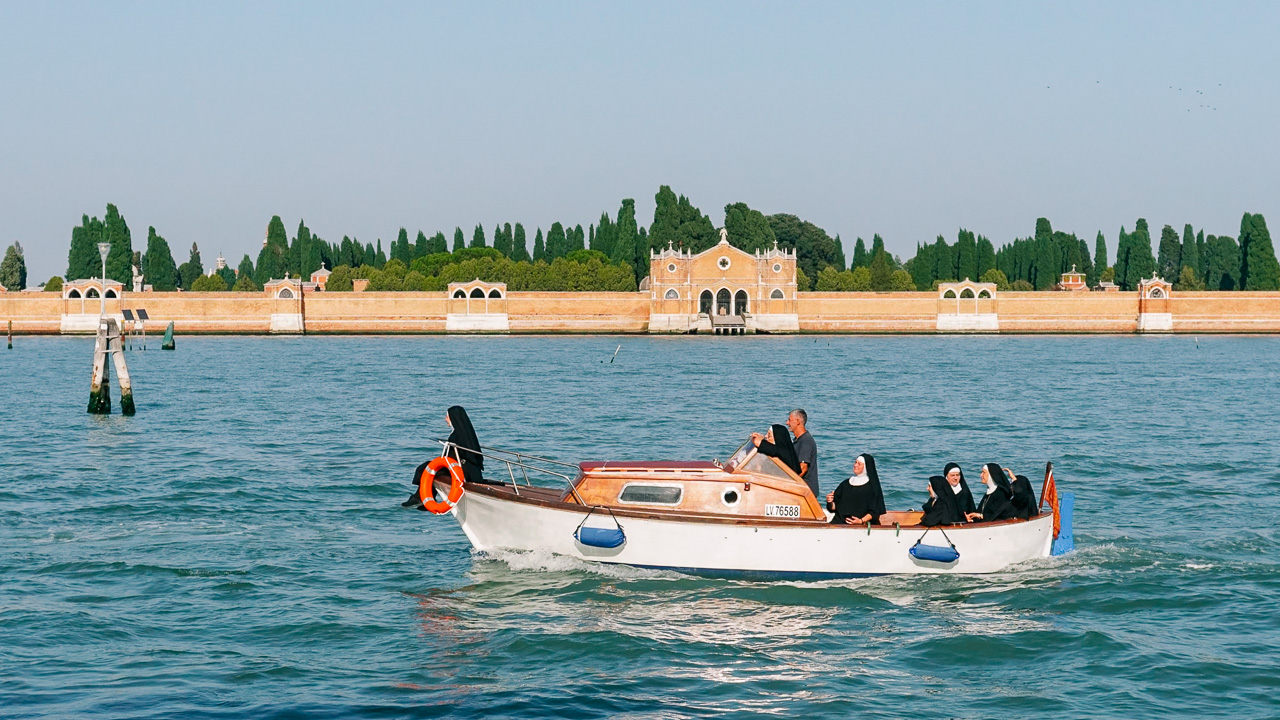 Venice Itineraries guide and a boat with nuns