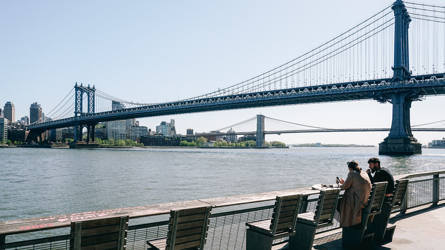 The Manhattan Bridge and two people having lunch for the Seven Years Of Travel Blogging article