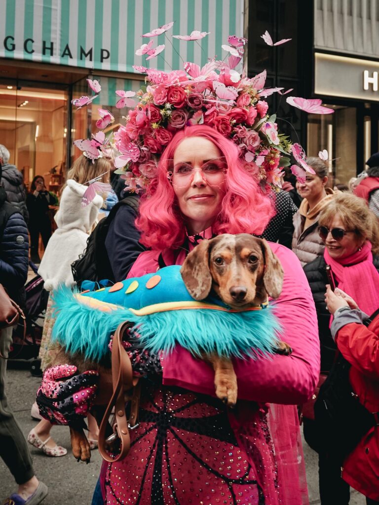 A lady in pink holding a dog street photography New York